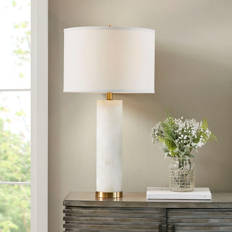 a white ceramic table lamp placed in a living room