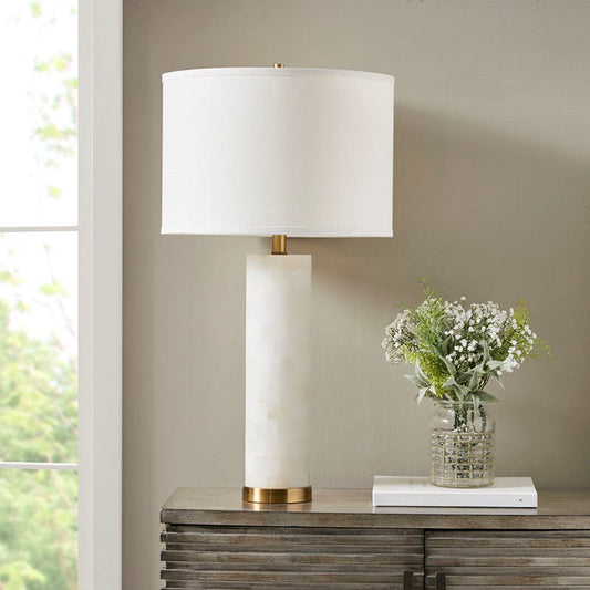 a white alabaster ceramic table lamp with gold base in a moden setting