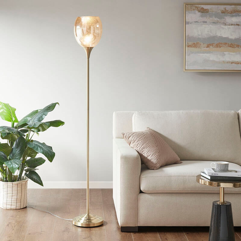 a midcentury modern floor lamp with mercury glass shade in a living room