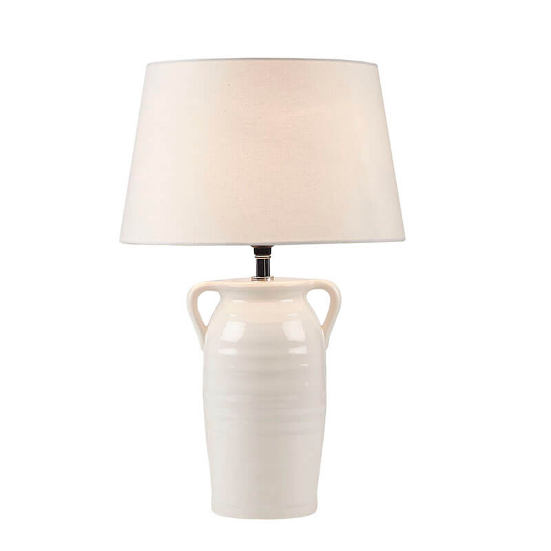 an illuminated vintage ceramic table lamp in a white background