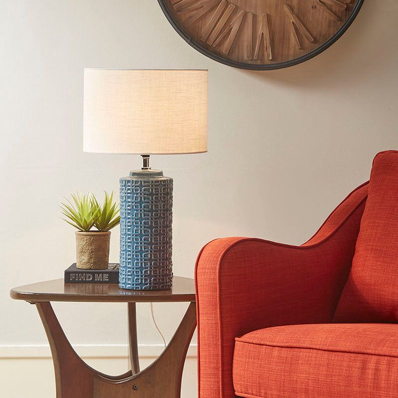 Ceramic table lamp on a side table switched on in a modern living room