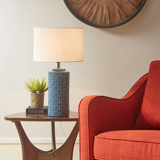 Ceramic table lamp on a side table switched on in a modern living room