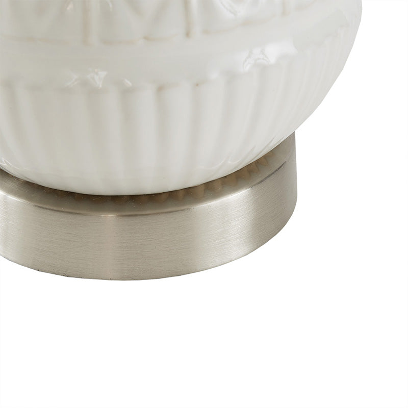 Close up view of the metal base sitting of the white ceramic table lamp