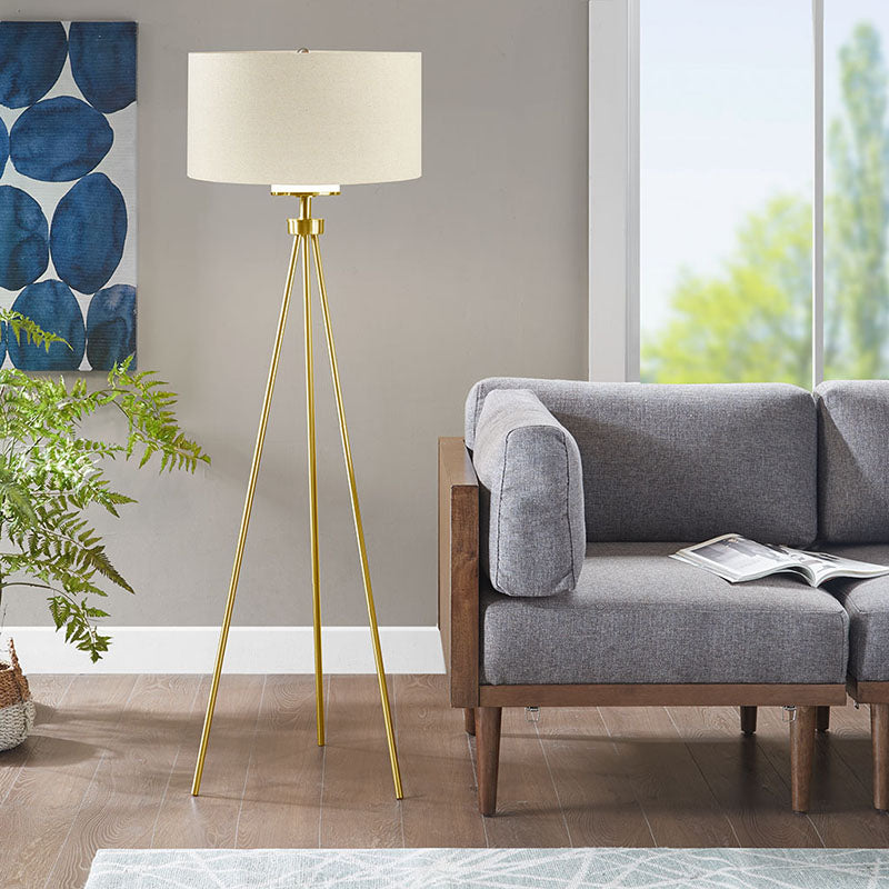 a modern gold floor lamp illuminating light beautifully in a living room