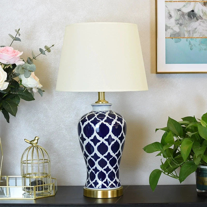 an illuminated blue ceramic table lamp placed on a table