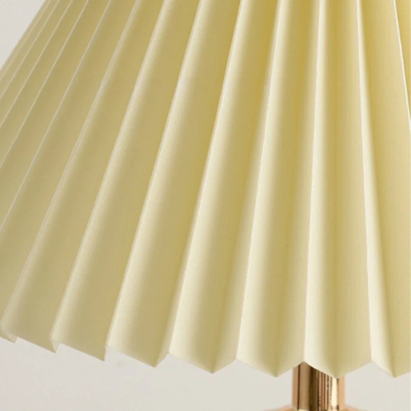 Ceramic table lamp showcasing its pleated lamp shade 