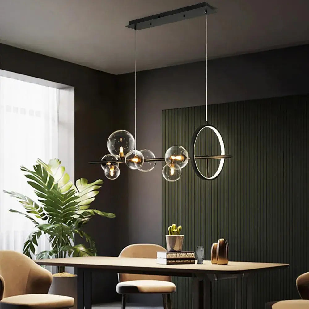 a kitchen island chandelier over a dining table in a modern setting