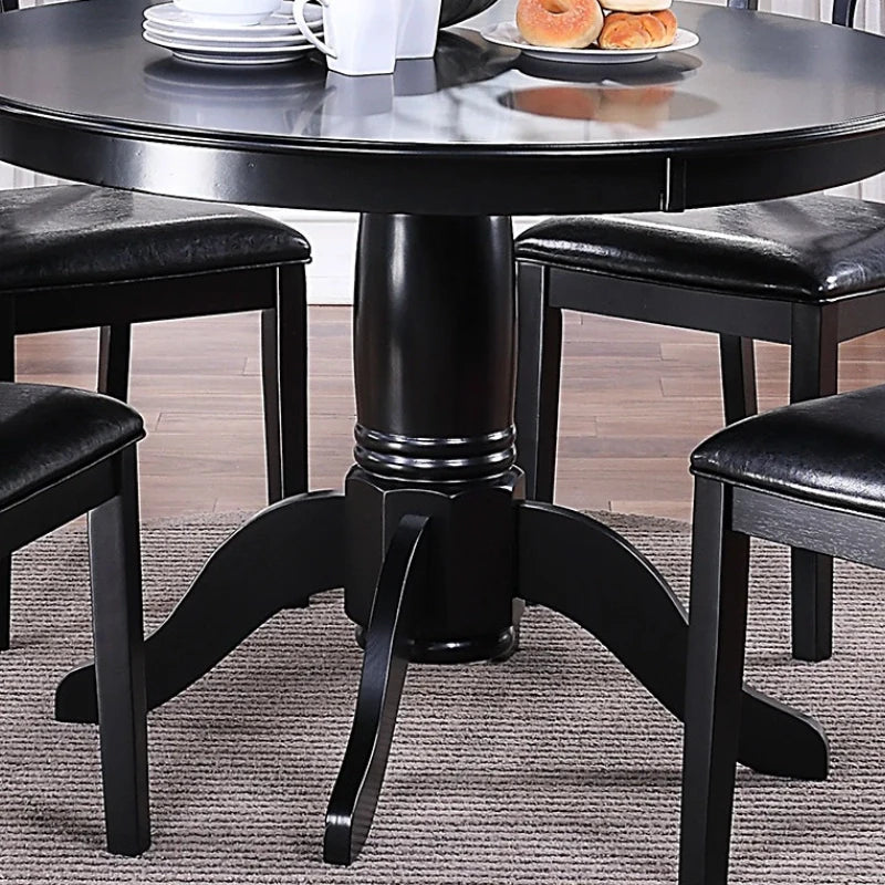 A round wooden dining table with pedestal base