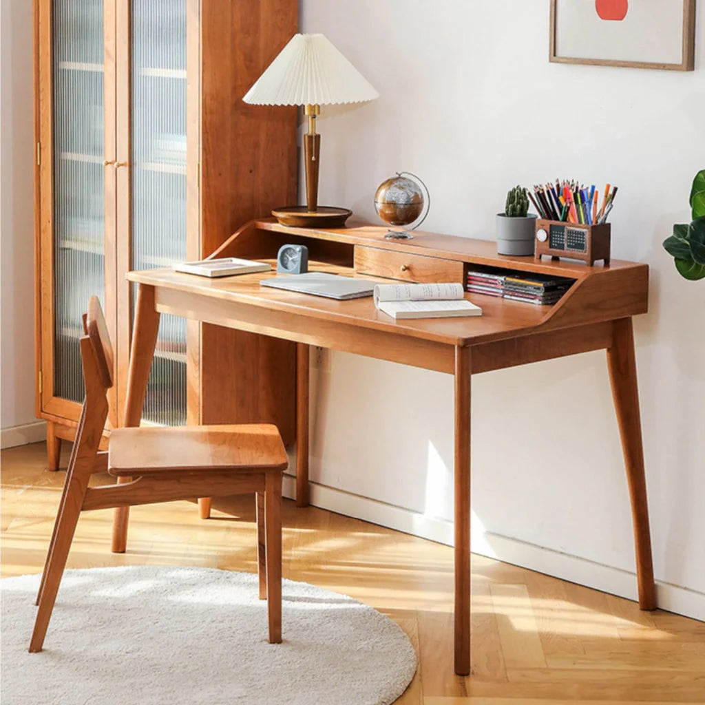 A natural cherry wood desk with a hutch and drawer, featuring clean lines, sculpted legs, and a bronze handle.