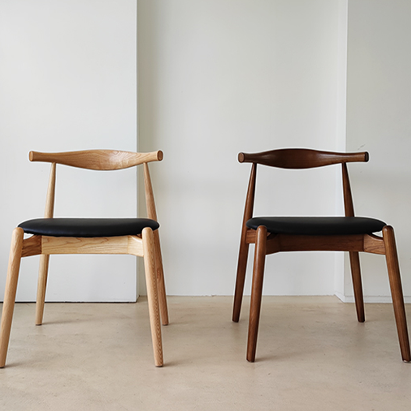 Two wood dining chair placed side by side in walnut and natural wood finish