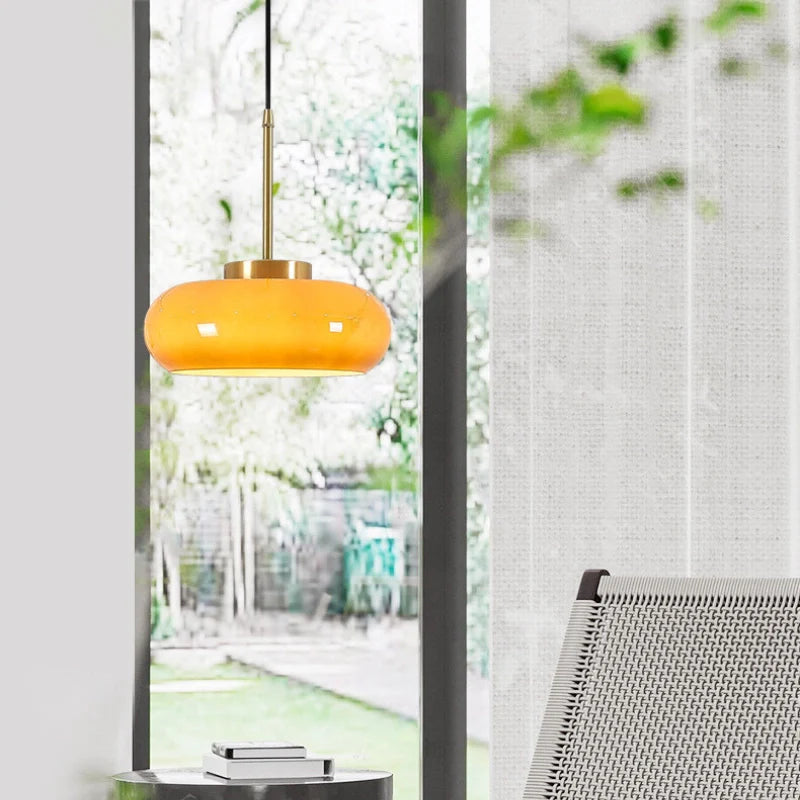 a glass pendant light with yellowish-brown bowl shade 