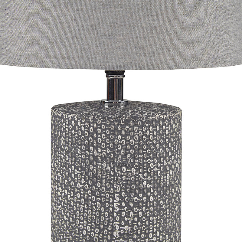 Up close view of the ceramic table lamp showing section of embossed base and lampshade