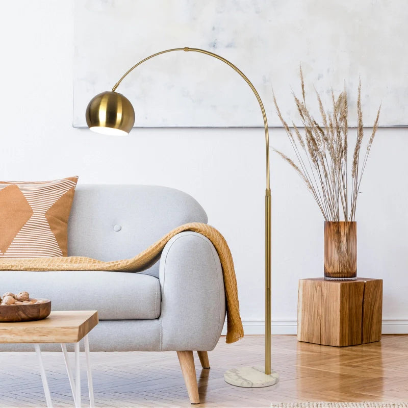 an arched modern floor lamp with round white marble base in a modern setting