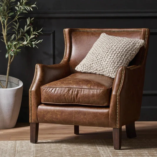 Brown leather accent chair with plush cushioning and fluffy toss pillow