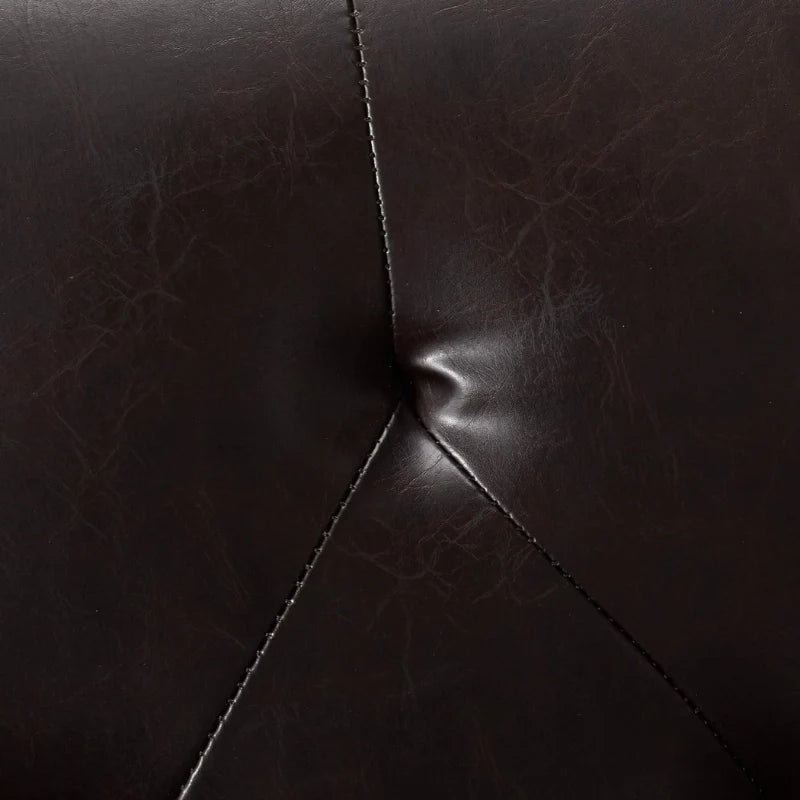 The tufted detailing of a leather accent chair 