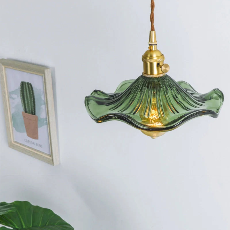 Ceiling mounted green glass pendant light showing floral lamp shade and brass lamp holder