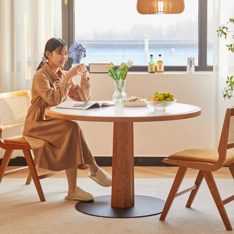 A Wood Pedestal Dining Table with White Stone Top in a Modern Living Room Setting