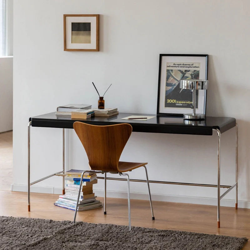 a mid-century modern black wood and metal desk with stainless steel legs