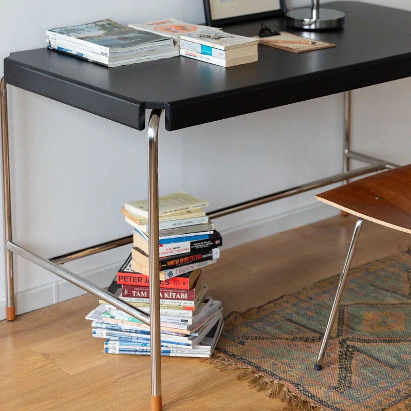 a black writing desk with stainless steel legs