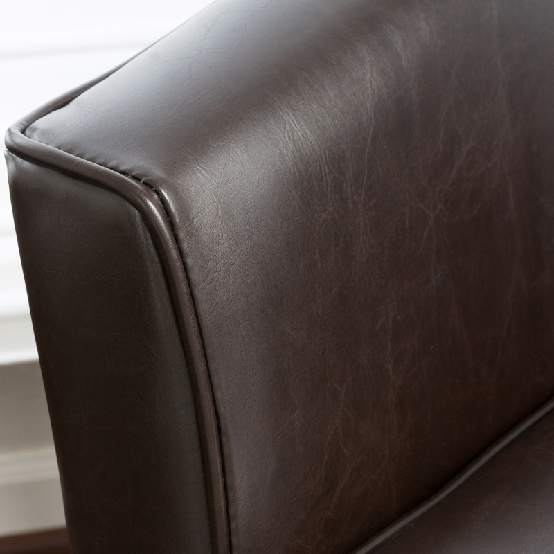 The backrest of a brown leather accent chair