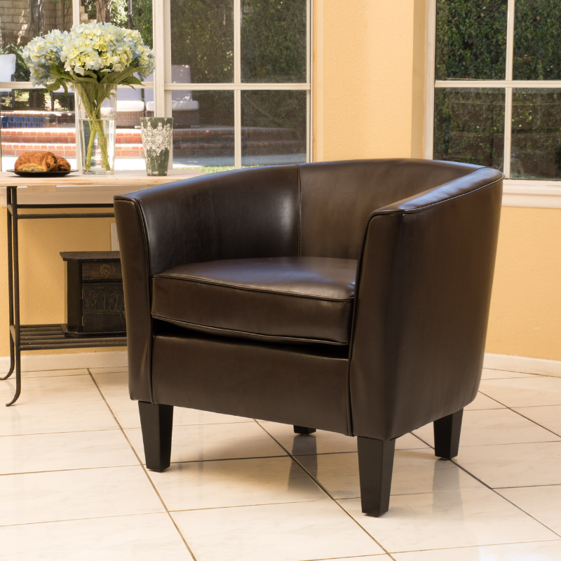 A brown leather accent chair in a modern living room 