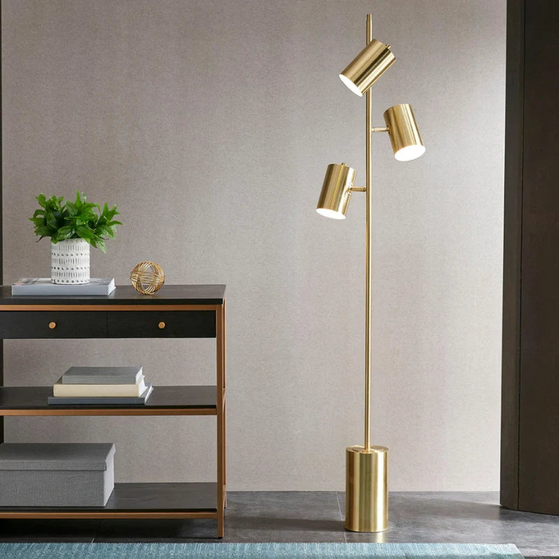 Modern Gold Floor Lamb with its 3 adjustable lights turned on over a study desk