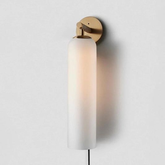 a modern plug in wall lamp with glass shade illuminating light softly in a living area