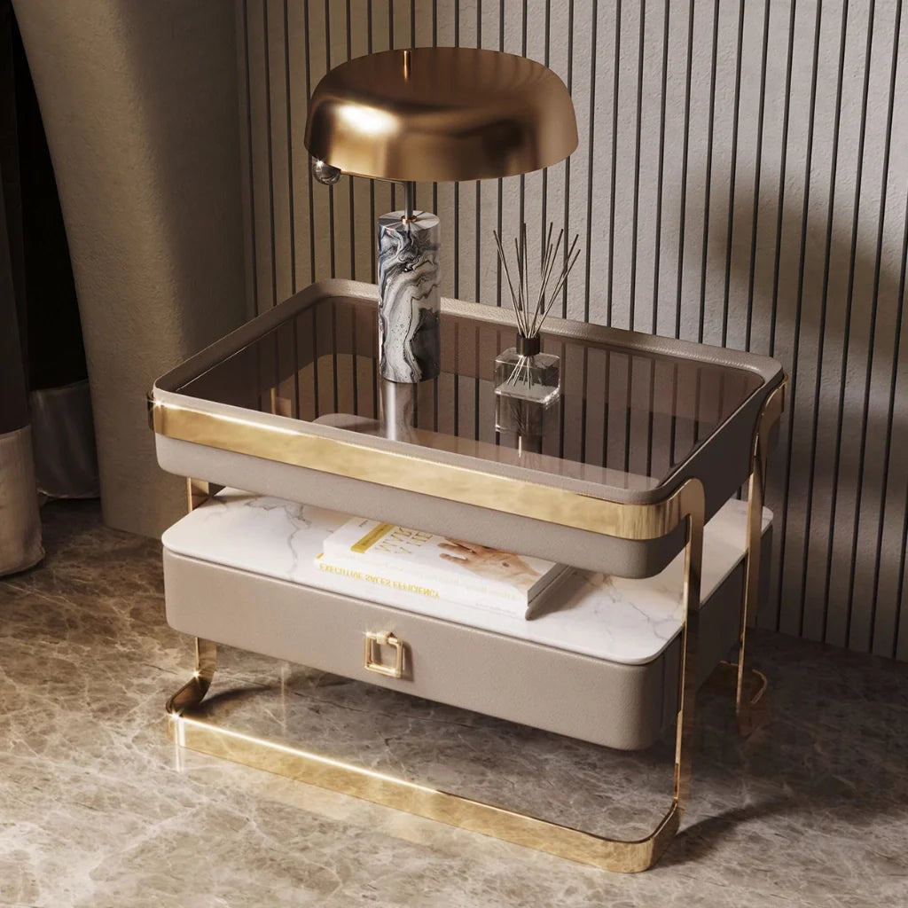 An image of modern nightstand with a sleek tempered glass top, PU leather drawer, gold metal frame, and open sintered stone shelf, showcasing a stylish and functional design perfect for bedside table ideas and contemporary bedroom aesthetics.