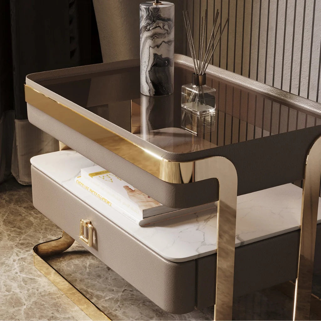 An image of modern nightstand with a sleek tempered glass top, PU leather drawer, gold metal frame, and open sintered stone shelf, showcasing a stylish and functional design perfect for bedside table ideas and contemporary bedroom aesthetics.