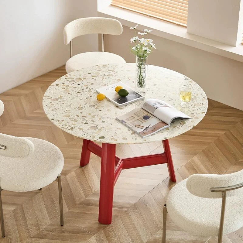 a wood dining table with a round tables top and a red  base