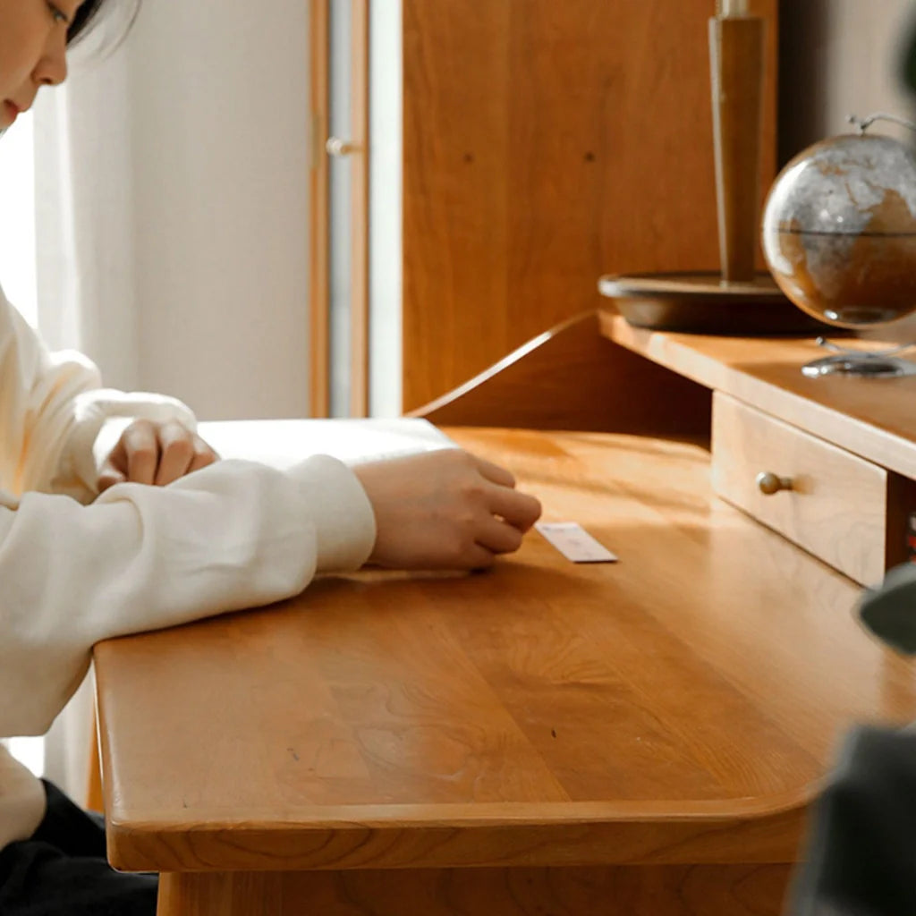 a wooden computer desk featuring a bronze-handled drawer and a practical hutch for storage.