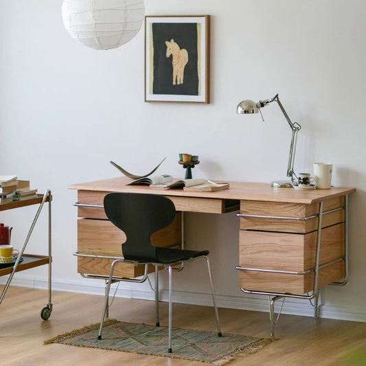 a natural trimline wooden desk with drawers and chrome tubular frame