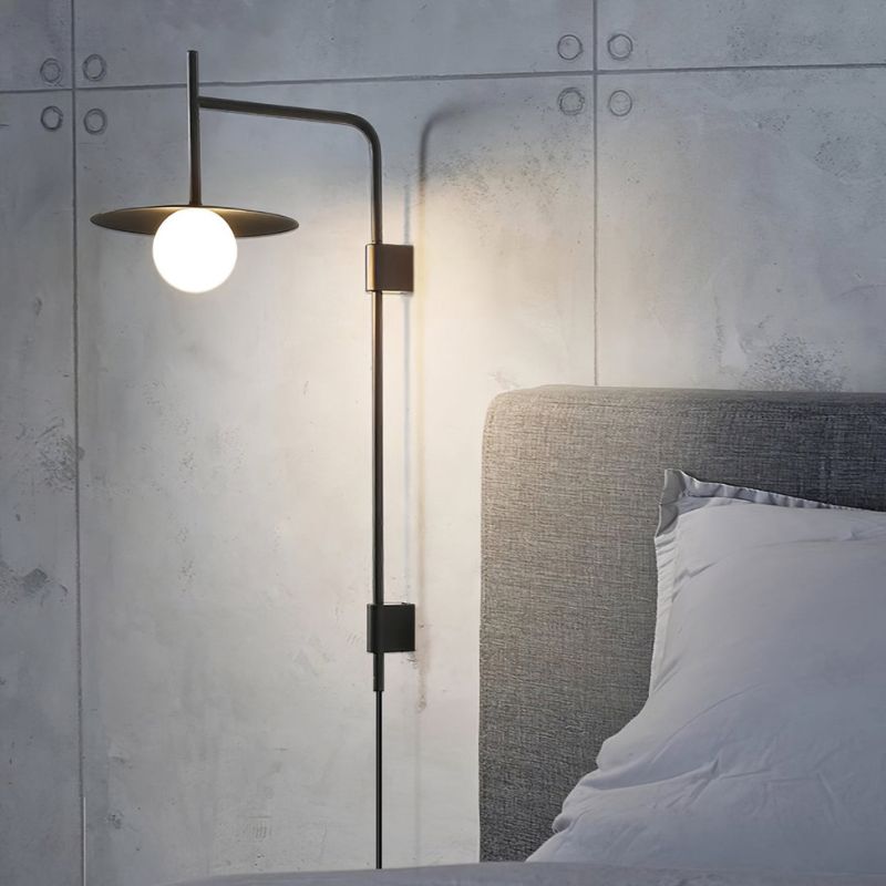 an illuminated plug in swing arm wall lamp in a bedroom