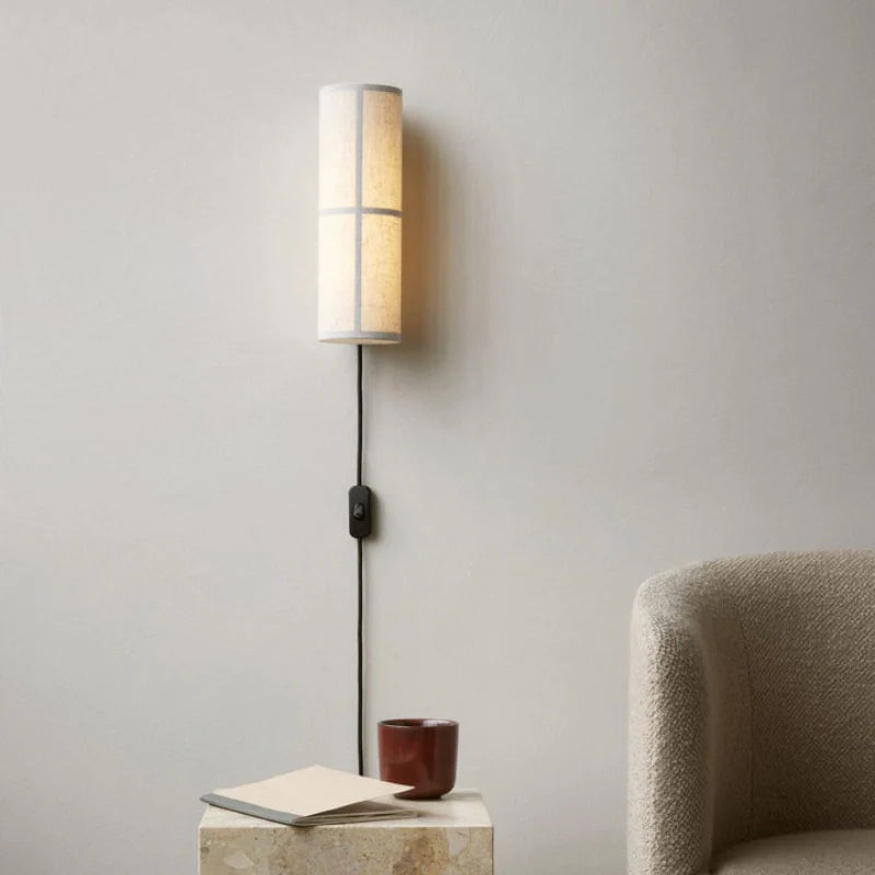 Plug in variant of Cylinder fabric wall sconce installed in a living room