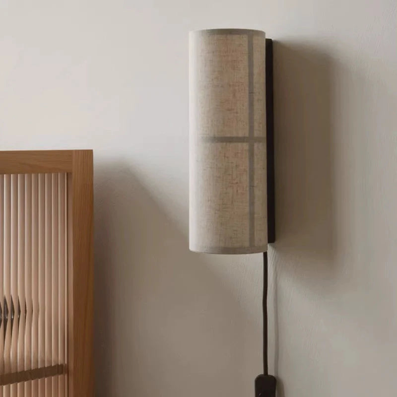 Cylinder fabric pug in wall sconce installed in a living room