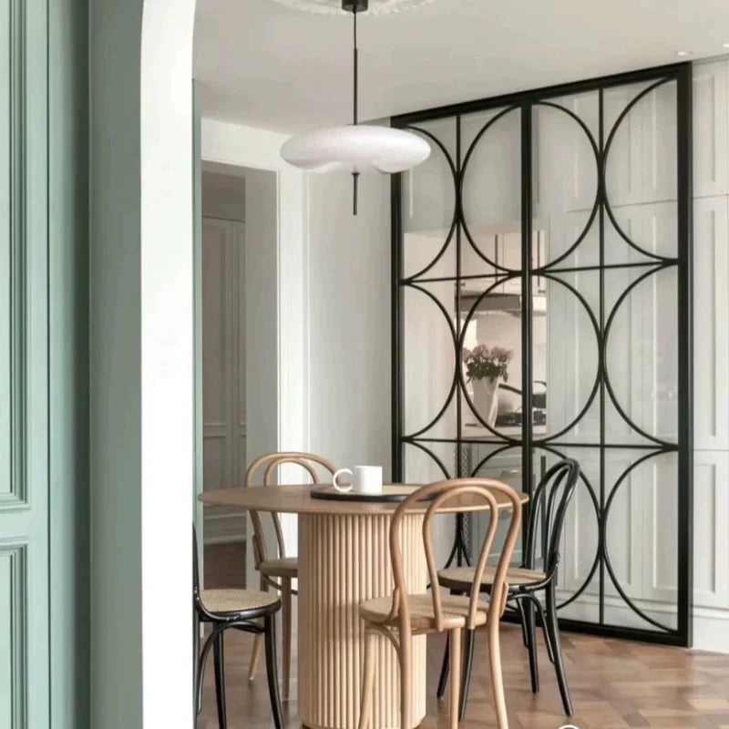 A Solid Wood Pedestal Dining Table in a Modern Dining Area in Natural Wood Color, in a modern dining area.