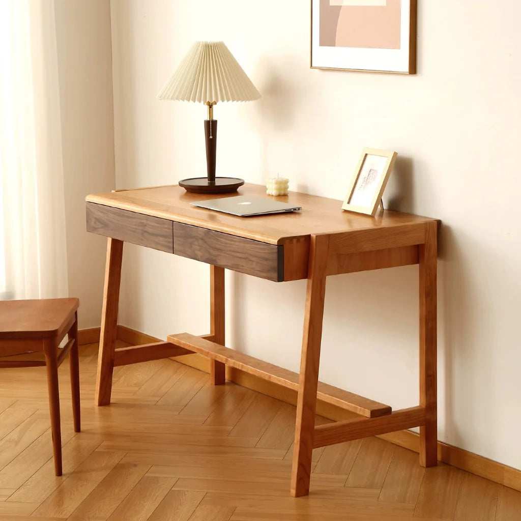 a solid cherry wood computer desk with two walnut-front drawers in a living area