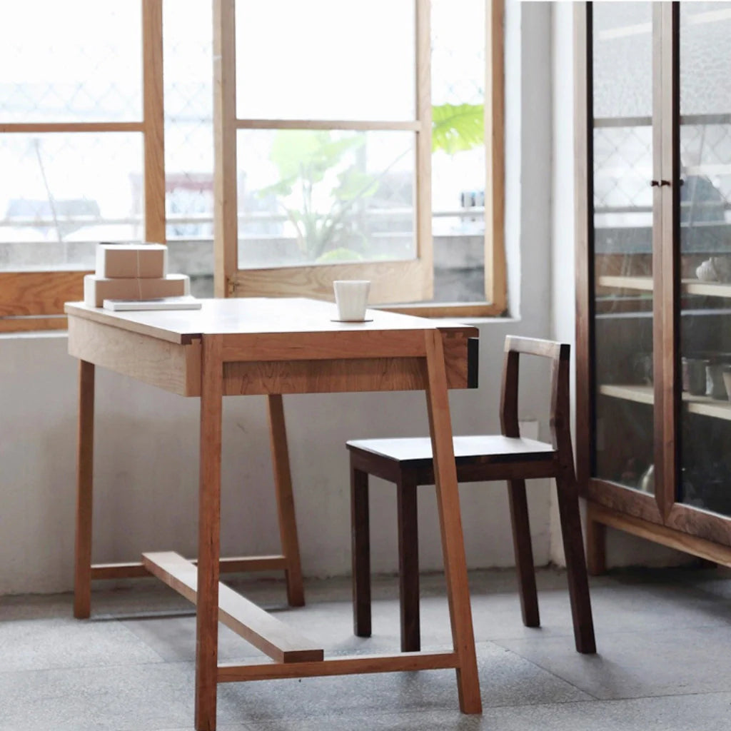 a wooden computer desk with two drawers, paired with a matching chair