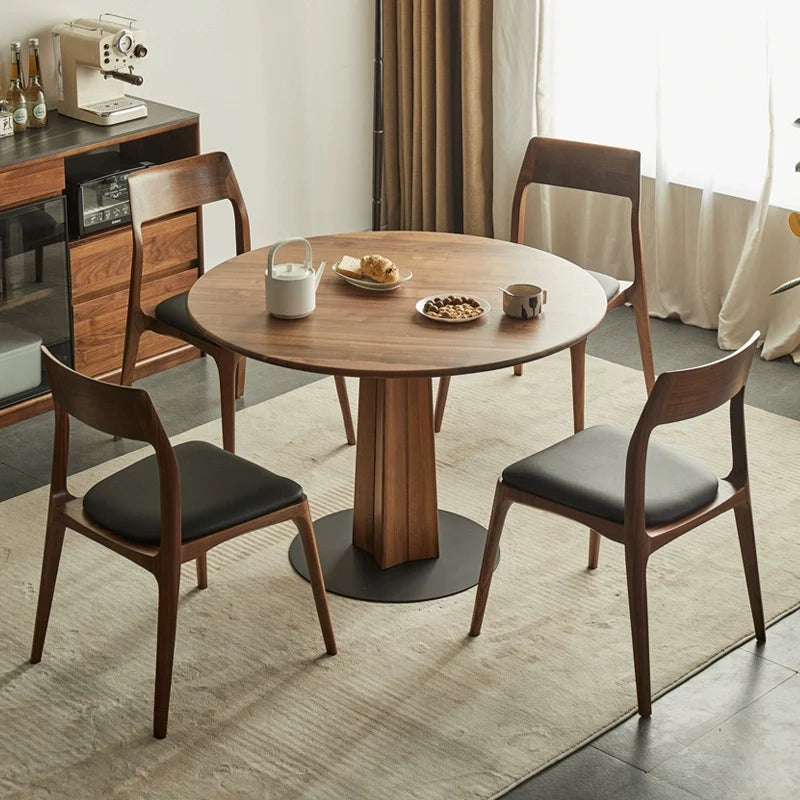 a round wood pedestal dining table paired with wood dining chairs