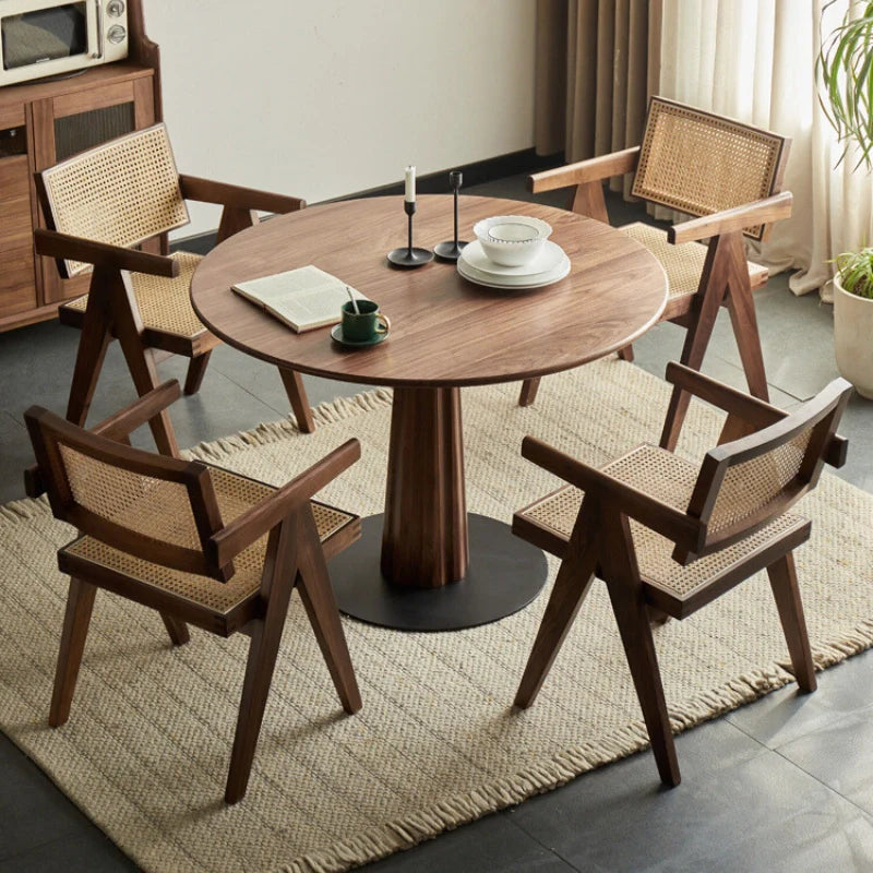 a round wood pedestal dining table paired with wood dining chairs