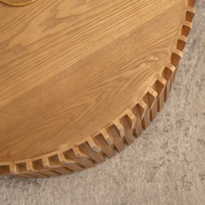 a solid wood round coffee table with vertical textured embossed design