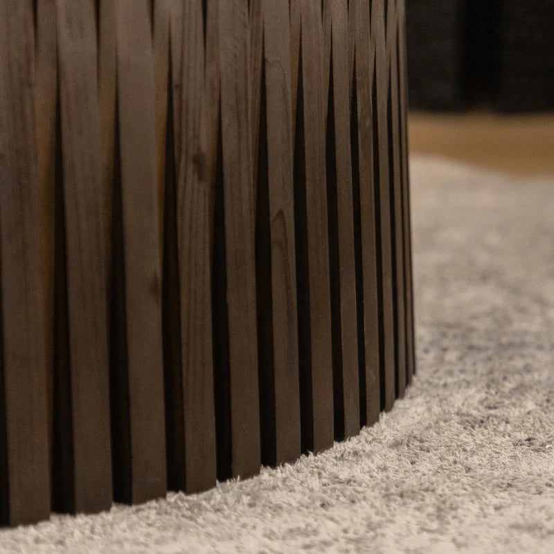 a wooden round coffee table with vertical textured embossed design