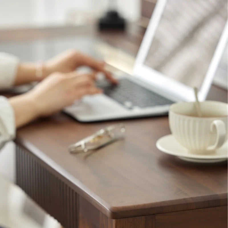 the smooth table top of a wood computer desk