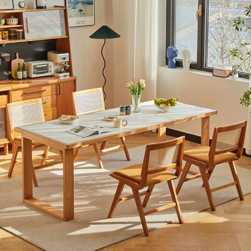 Rattan Dining Chairs with Cushiion placed around a Wood Dining Table