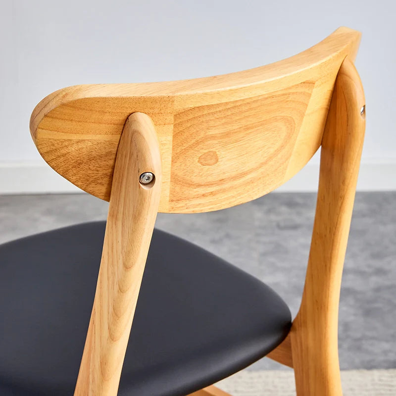 Back view of wood dining chair showing its curved ergonomic backrest