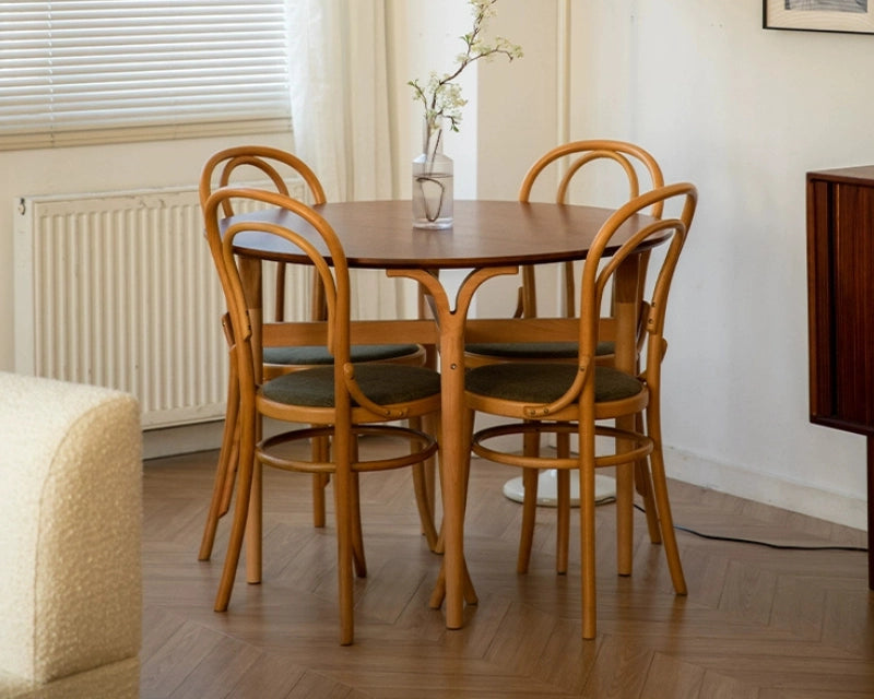 A round wooden dining table with 4 dining chairs