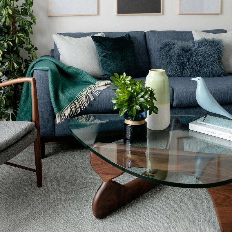 Glass and wood coffee table with brown base complementing a modern living room setting