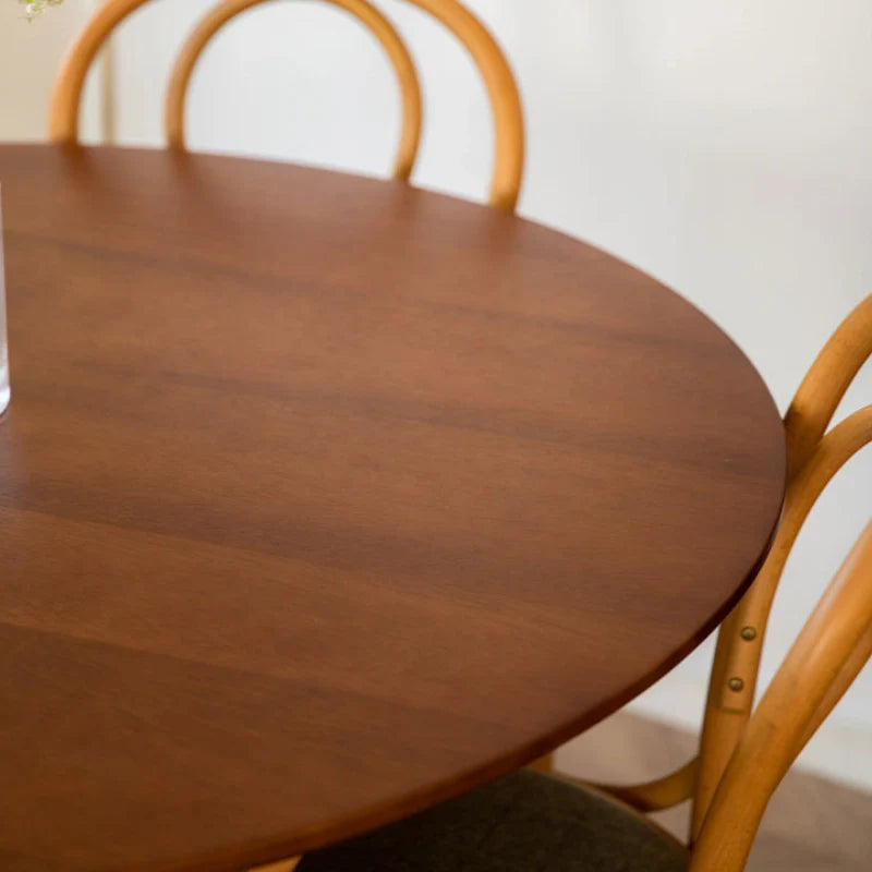 a round wood dining table with 2 thonet chairs