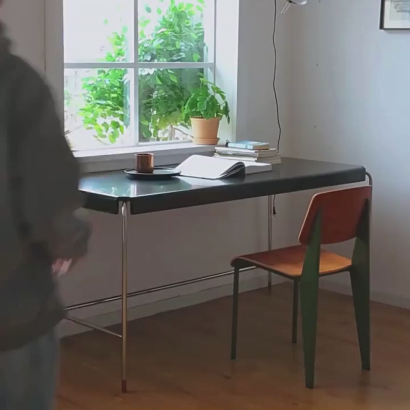 a mid-century modern black wood and metal desk paired with a matching chair