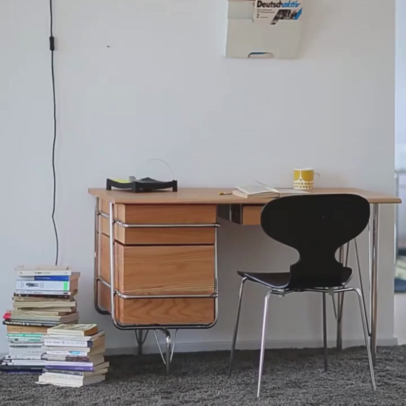 a solid wood desk with drawers and stainless steel frame